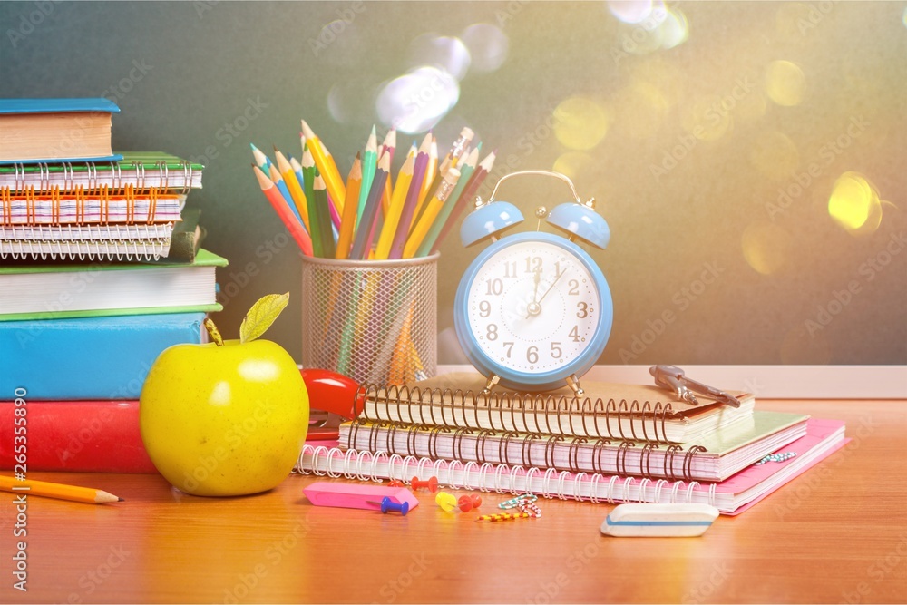 Colorful school supplies on blackboard background