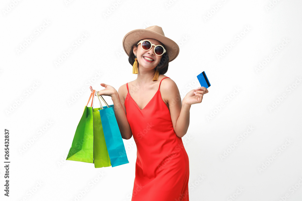 Portrait of beautiful girl wearing dress and sunglasses holding shopping bags.