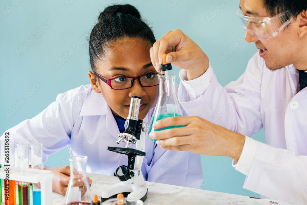 Male Asian science teacher teaching and doing chemistry lab test to curious African American element