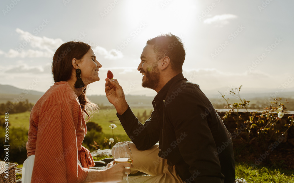 Couple on a romantic date sitting in a vineyard