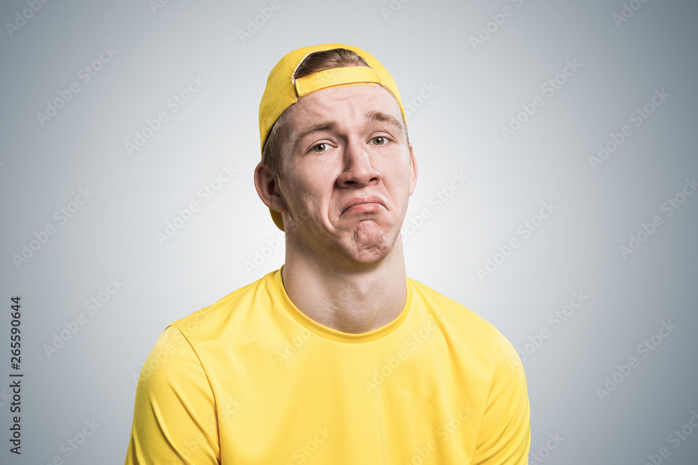 Unhappy young guy looking at camera