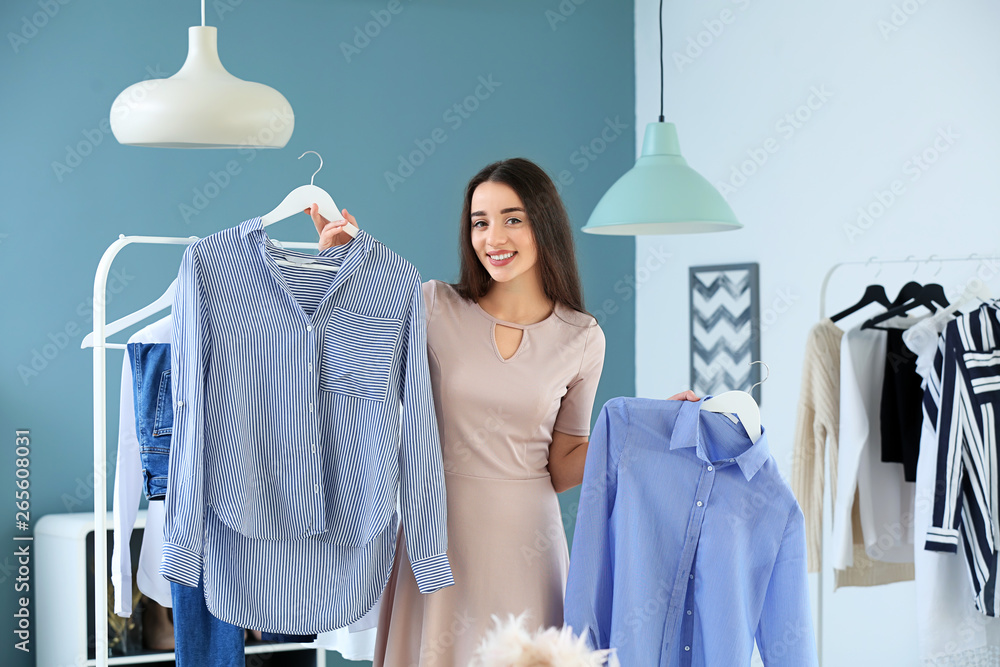 Young woman choosing clothes in dressing room