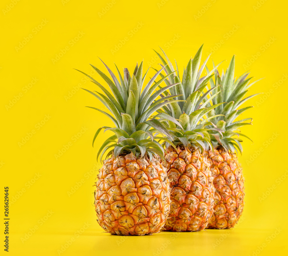 Beautiful fresh pineapple isolated on bright yellow background, summer seasonal fruit design idea pa