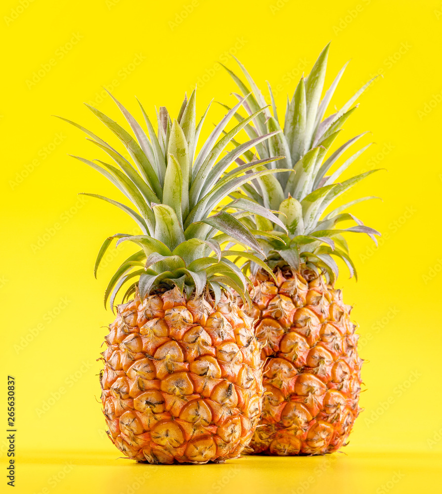 Beautiful fresh pineapple isolated on bright yellow background, summer seasonal fruit design idea pa