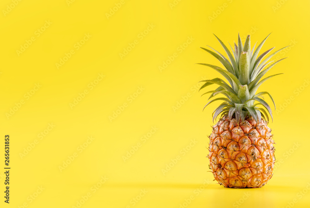 Beautiful fresh pineapple isolated on bright yellow background, summer seasonal fruit design idea pa