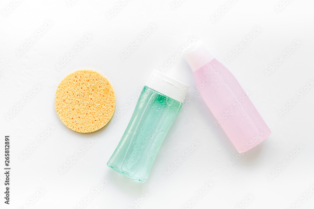 facial tonic, lotion and sponge for face care on white background top view mock up