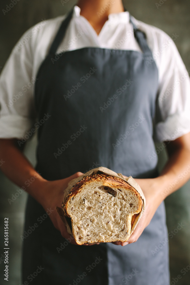 Woman baker with a bread loaf in bakery