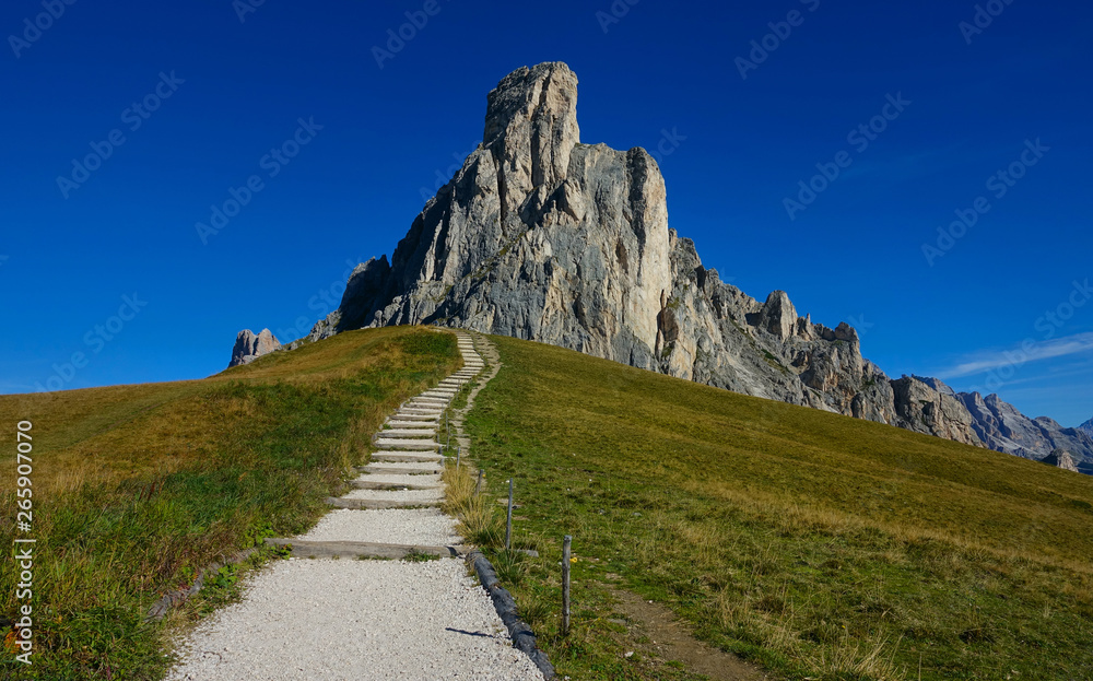 碎石路通向陡峭的草地，通向壮观的岩石山。