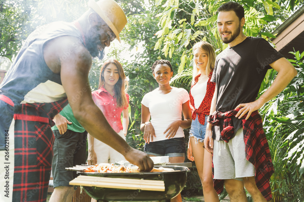 Group of people toasting beers celebration and having barbecue party outdoors garden