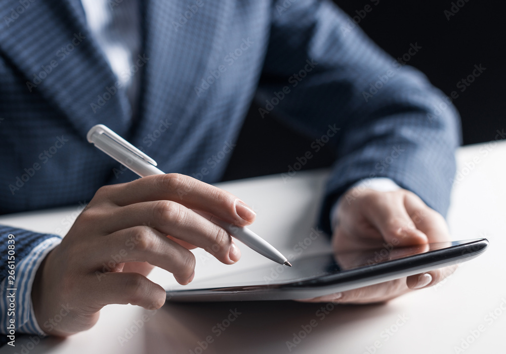 Man in business suit sitting at desk with tablet