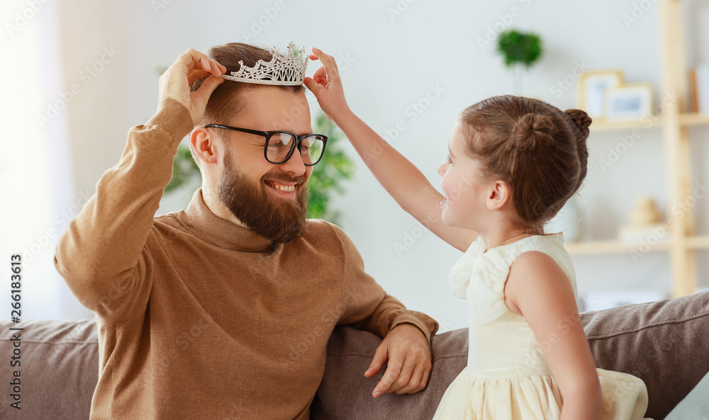 happy fathers day! child daughter in crown does makeup to daddy.