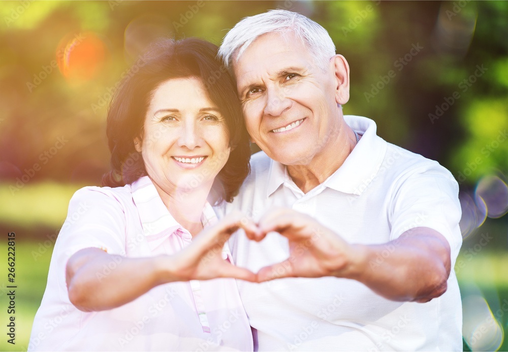 Portrait of happy senior couple showing heart sign