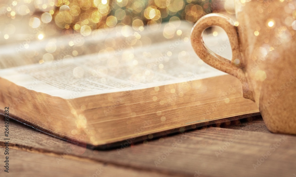 Open book on old wooden table.