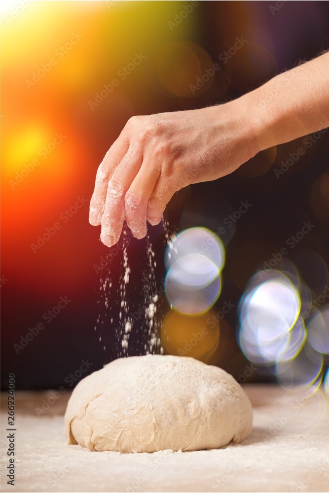 Womans hands knead the dough close up