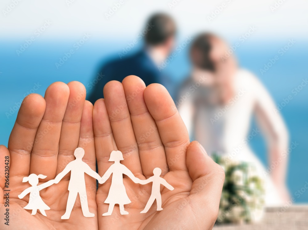 Love and relationships concept - closeup of mans cupped hands showing paper  family