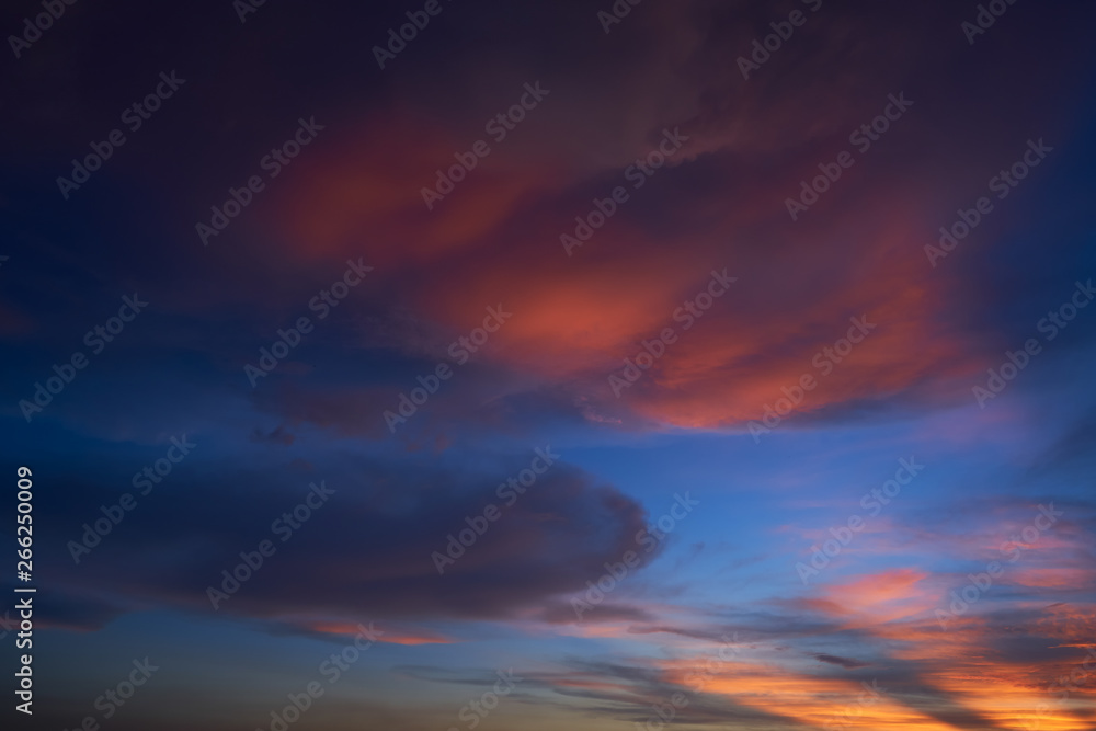 Beautiful vibrant orange cloud and blue sunset sky .