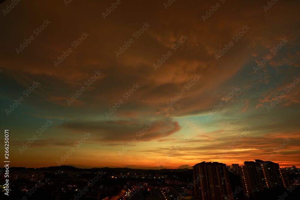 Beautiful vibrant orange cloud and blue sunset sky .