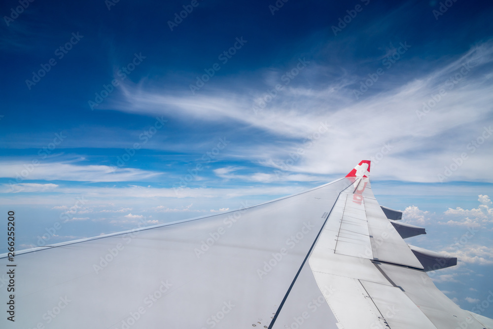 View cloudscape and airplane wing from the passenger compartment