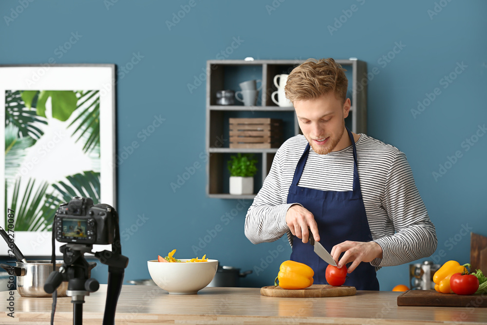 年轻男性美食博主在厨房录制视频