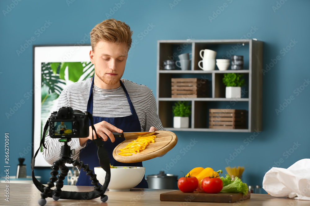 年轻男性美食博主在厨房录制视频