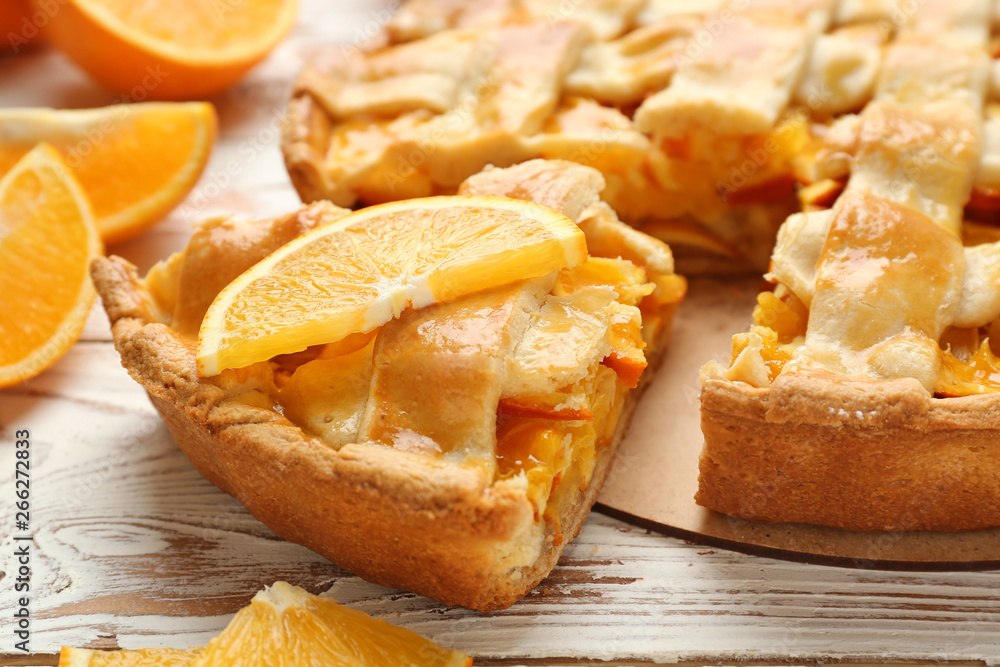 Tasty orange pie on wooden table, closeup