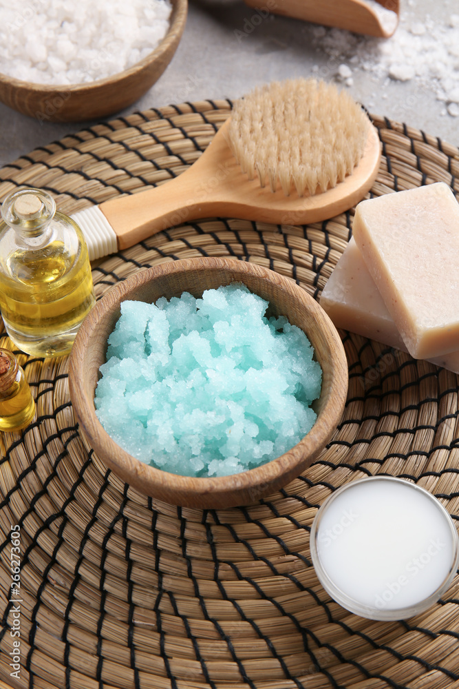 Bowl with body scrub, brush and soap on table