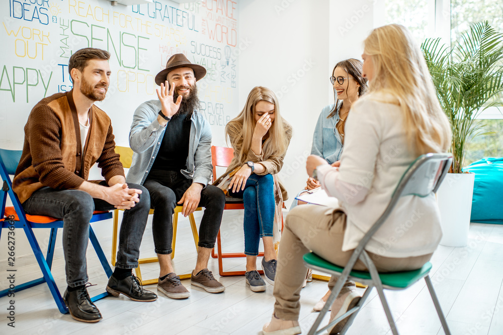 Group of young people sitting together during the psychological therapy with psychologist solving so