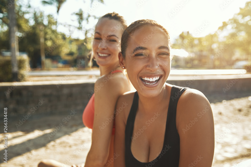 Laughing young women taking a break from an outdoor workout