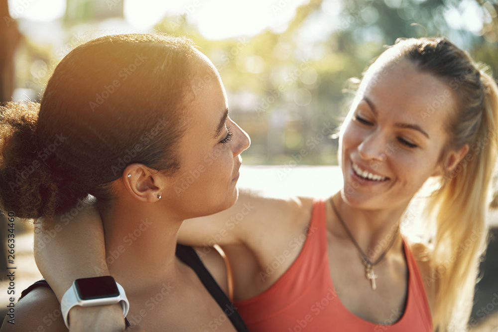 Fit friends in sportswear standing outside on a sunny day