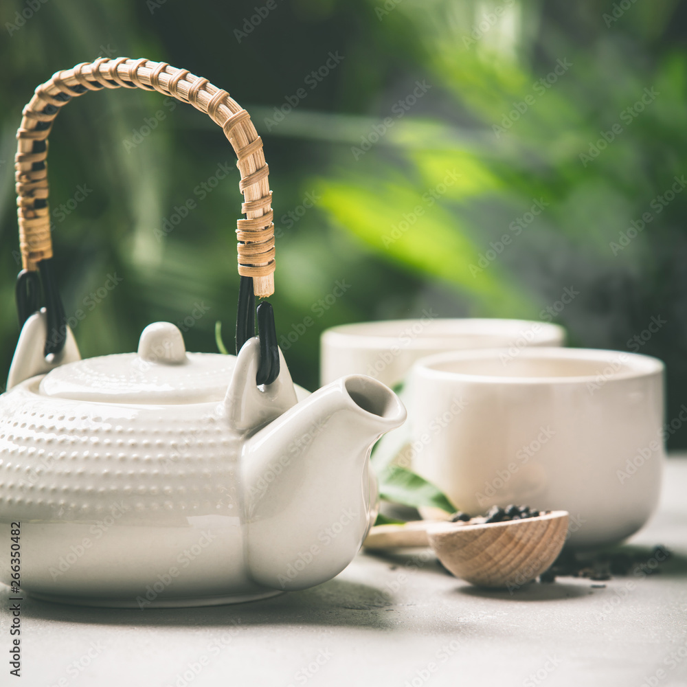 Tea composition on tropical leaves background, close up