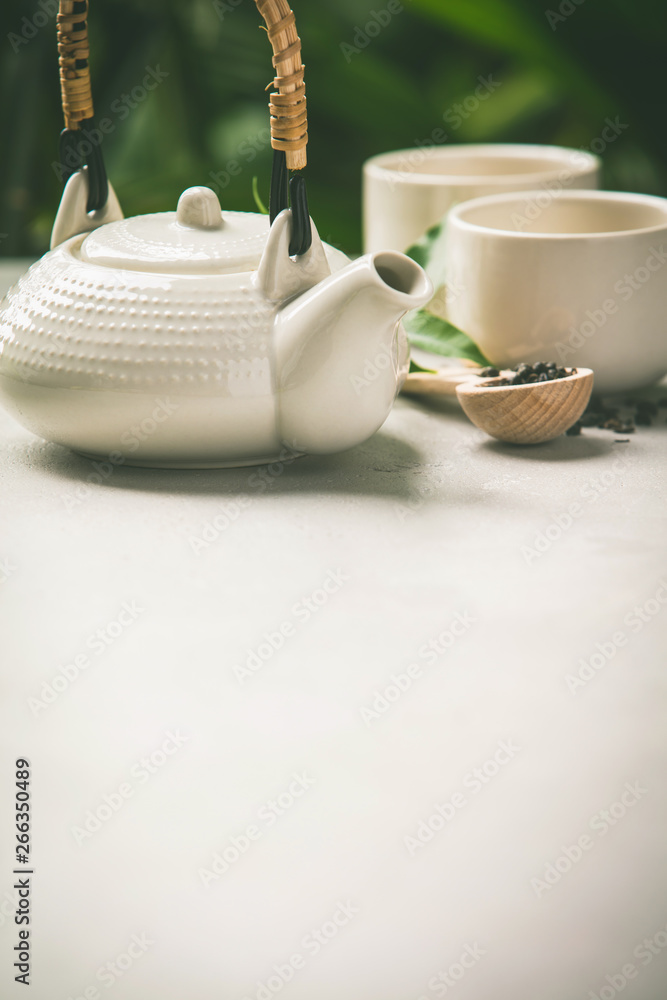 Tea composition on tropical leaves background, close up