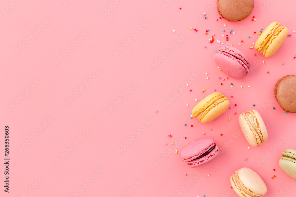 Brignt macarons for sweet break on pink background top view mock up