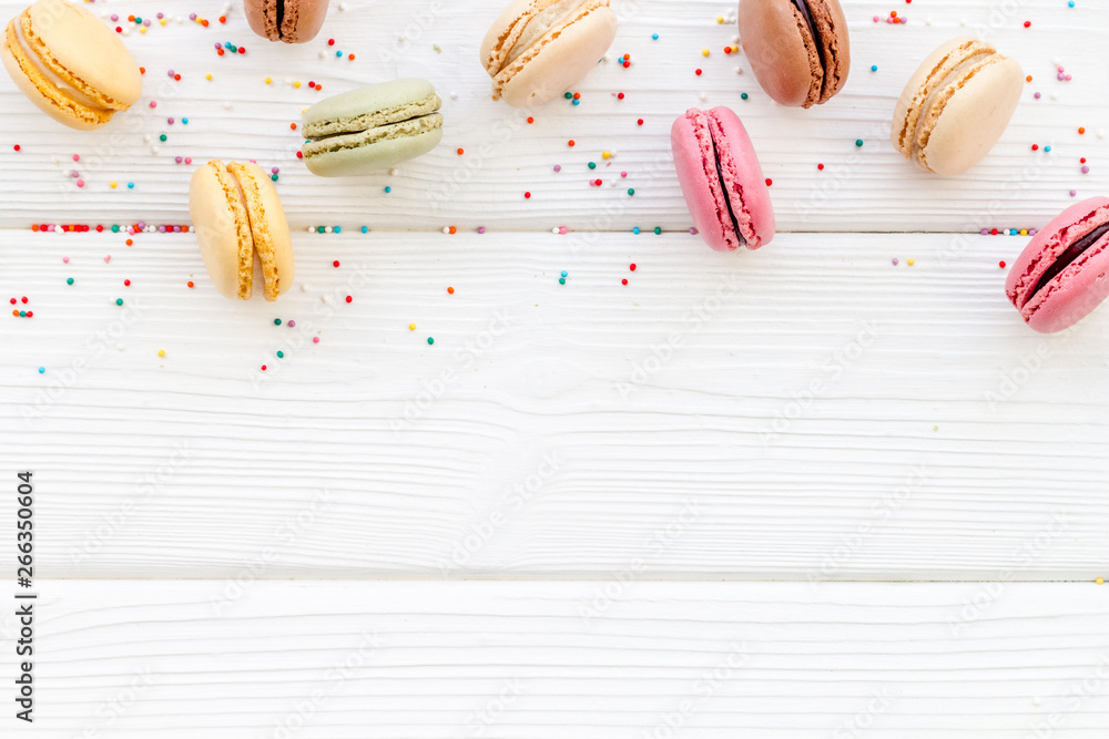 Macarons dessert pattern on white wooden background top view copy space