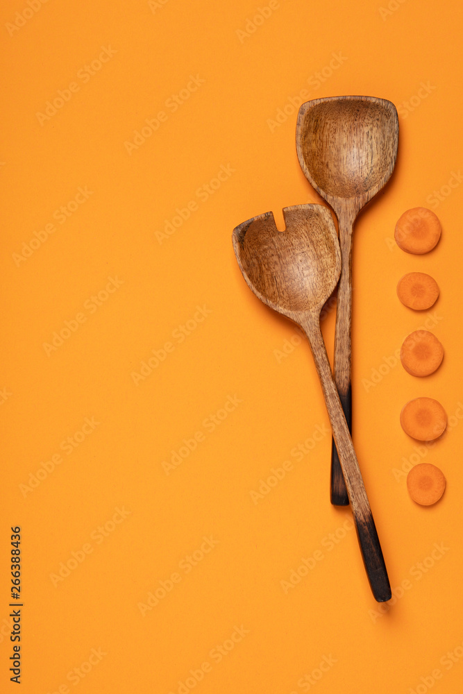 Wooden serving spoons on colorful background