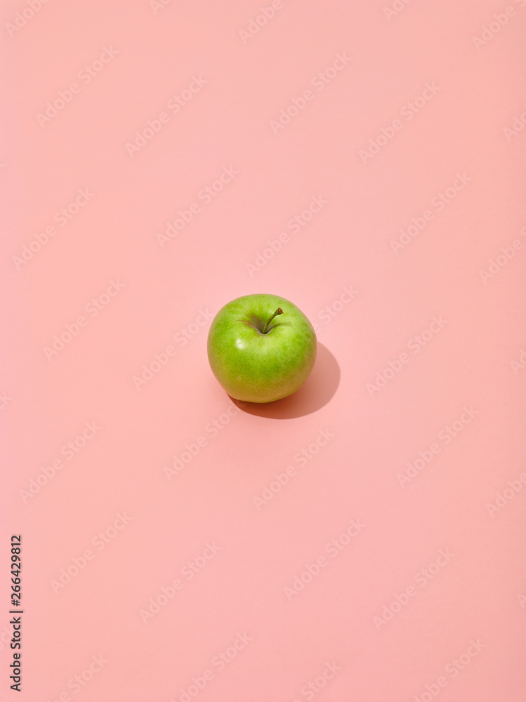 green apple on pink background