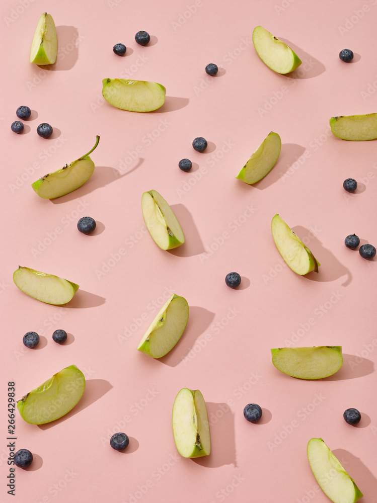 apple pieces and blueberries on pink background