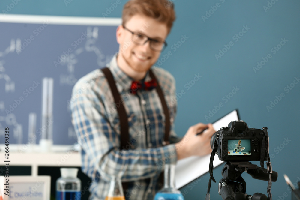 Young male blogger recording video in laboratory