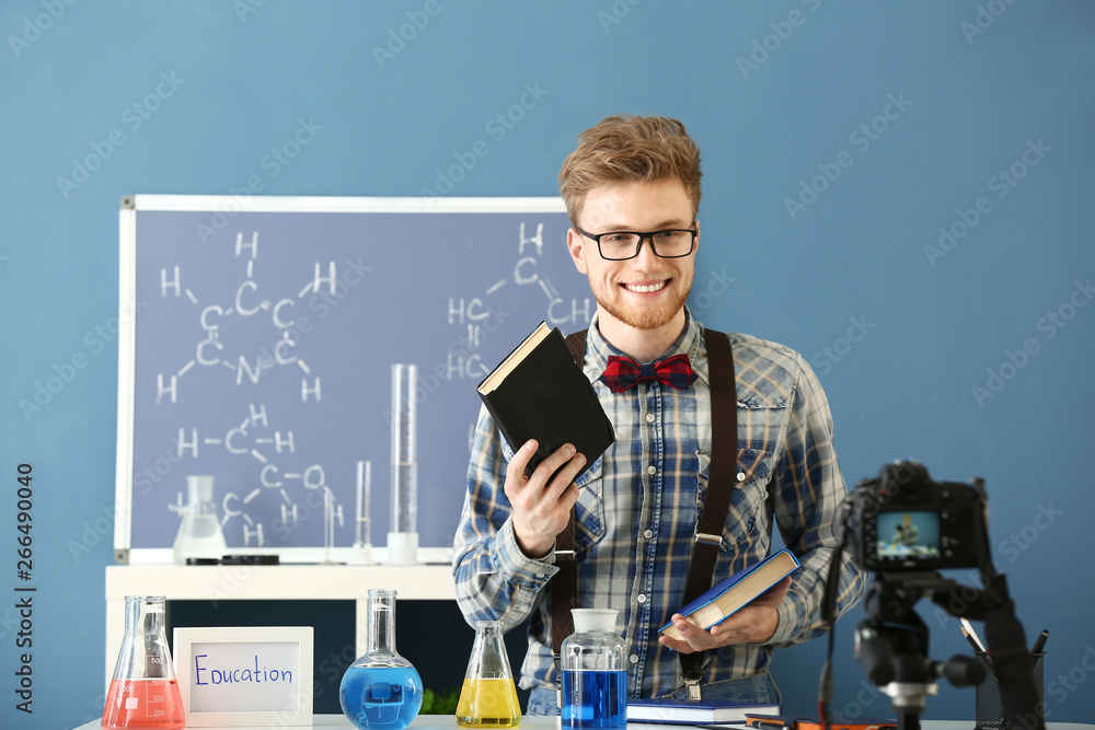 Young male blogger recording video in laboratory