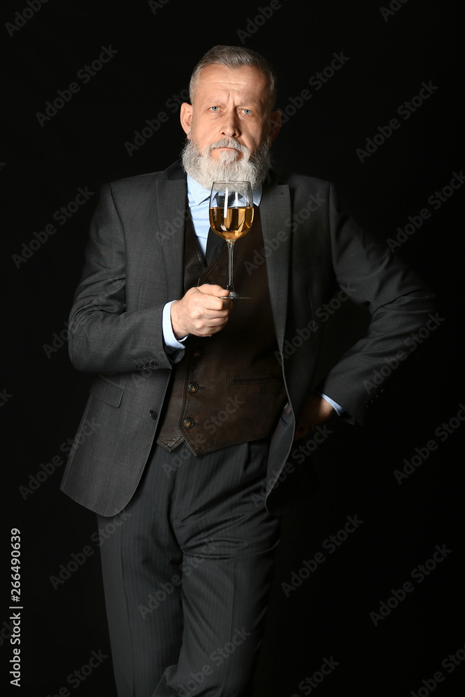 Portrait of elegant mature sommelier on dark background