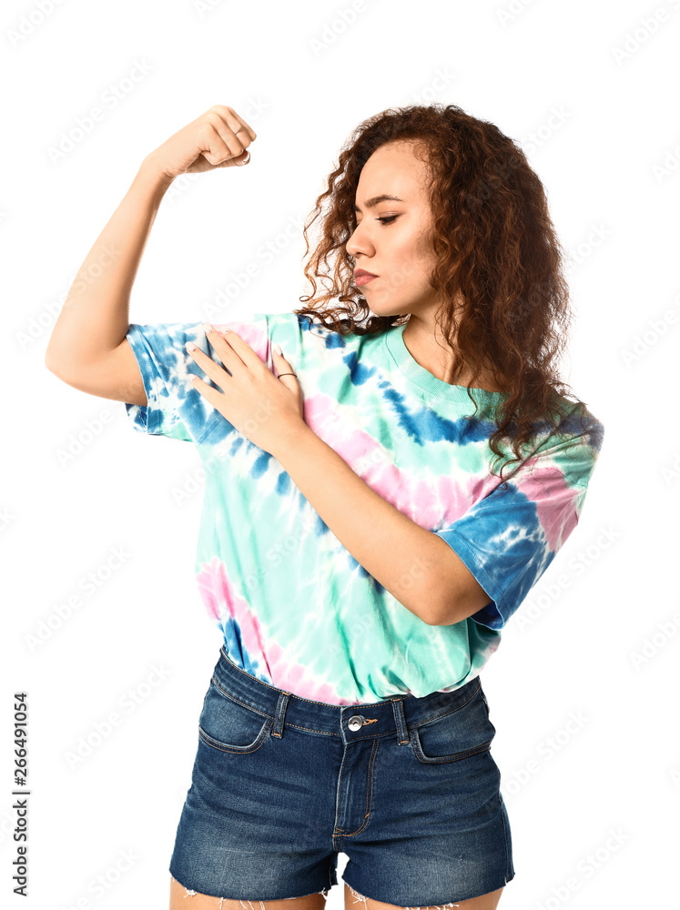 Beautiful young woman showing muscles on white background