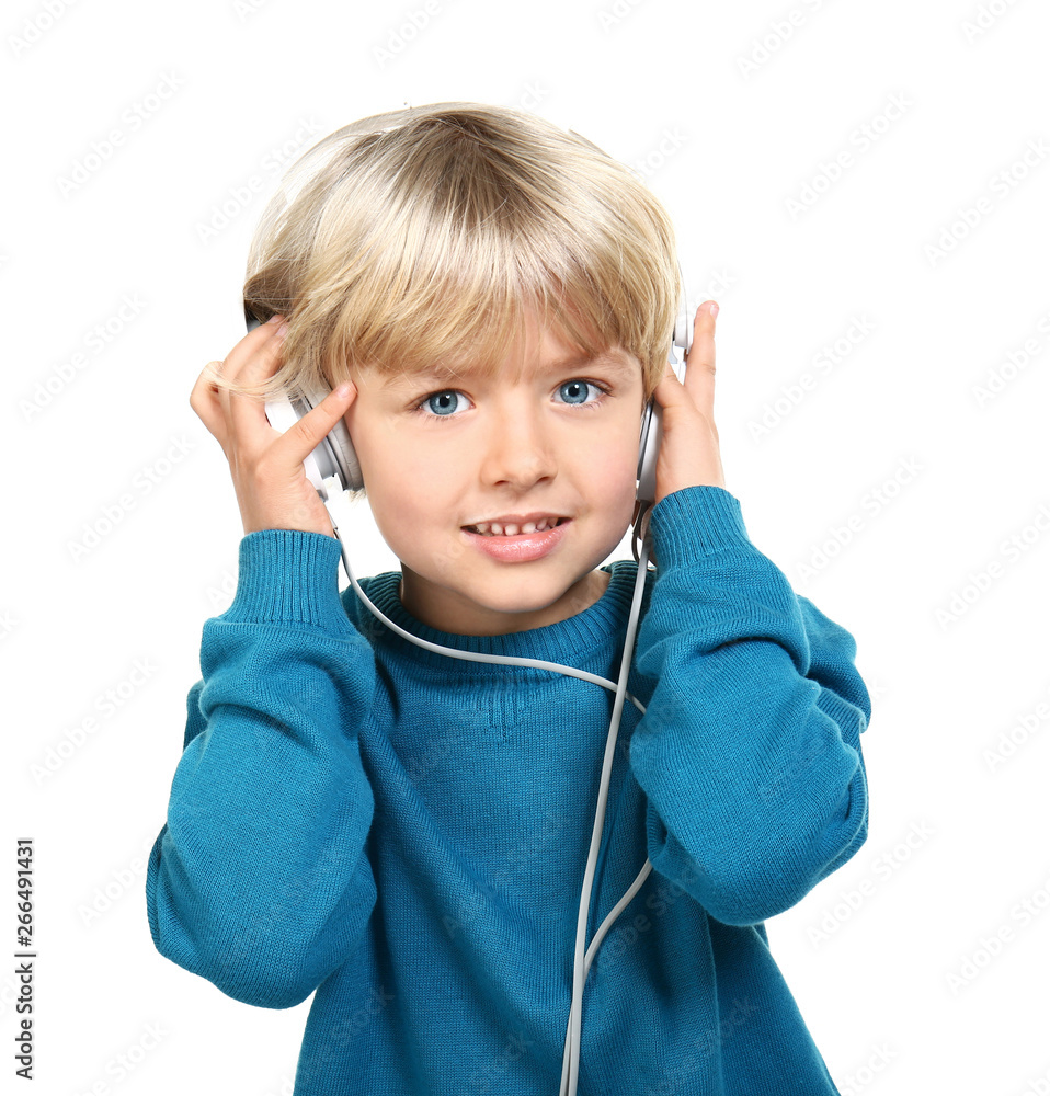 Cute little boy listening to music on white background