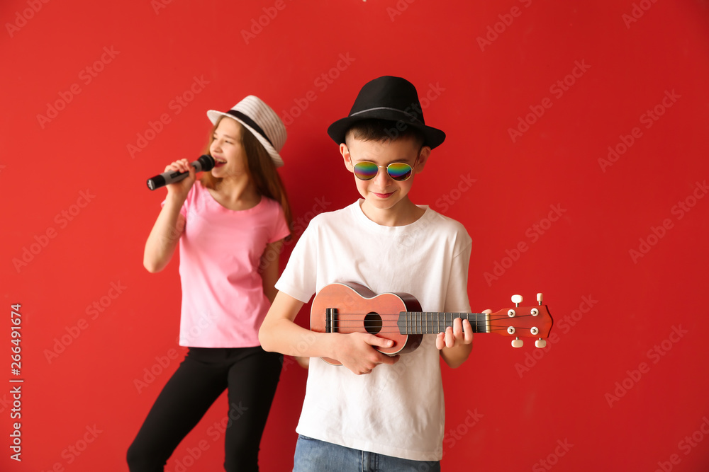 Little musicians playing against color background