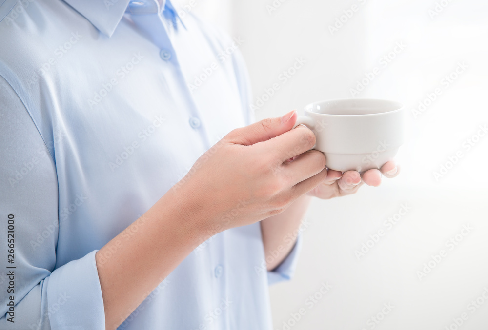 Side view of asia young business woman in blue shirt dress standing lying on the wall beside window 