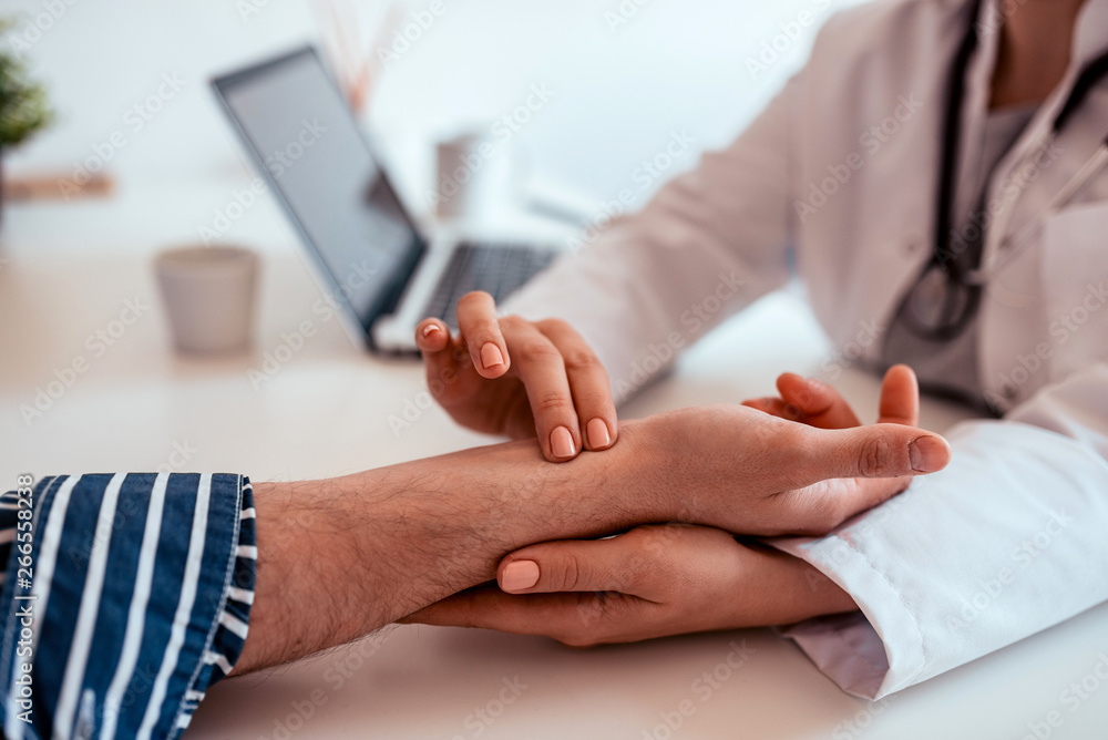 Checking patients pulse, close-up.