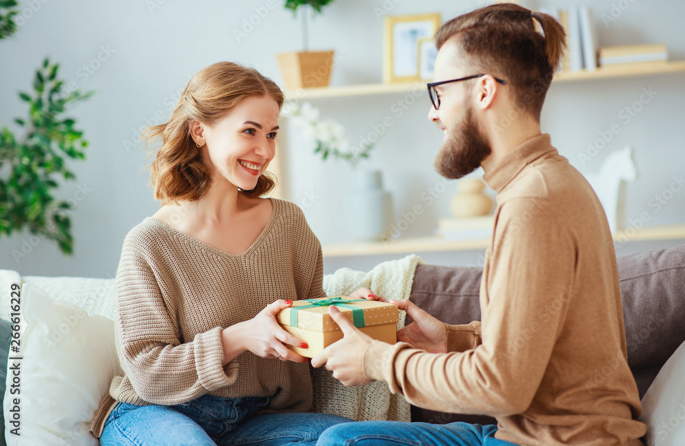 Happy married couple man and woman give a gift for holiday