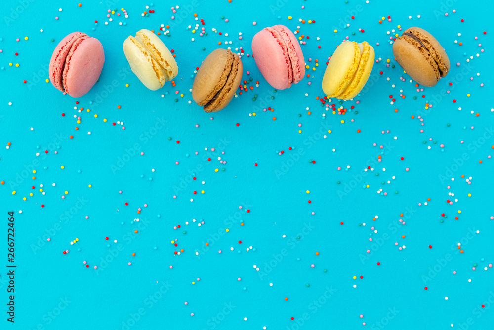 Brignt macarons for sweet break on blue background top view mock up