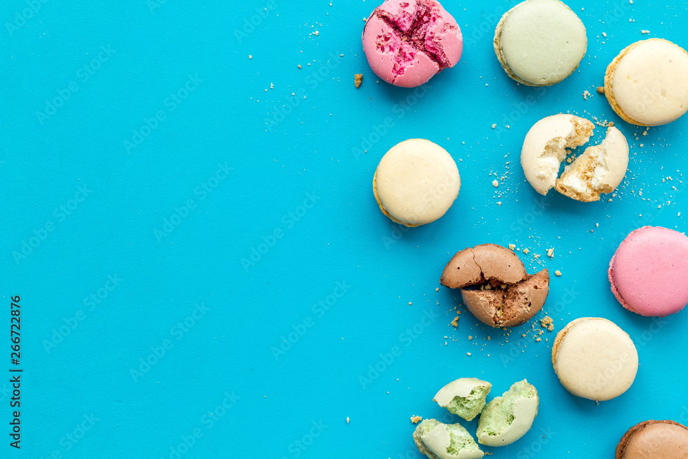 Macarons dessert pattern on blue background top view copy space