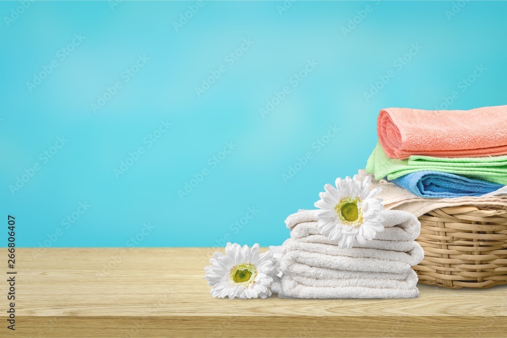 Laundry Basket with colorful towels on background