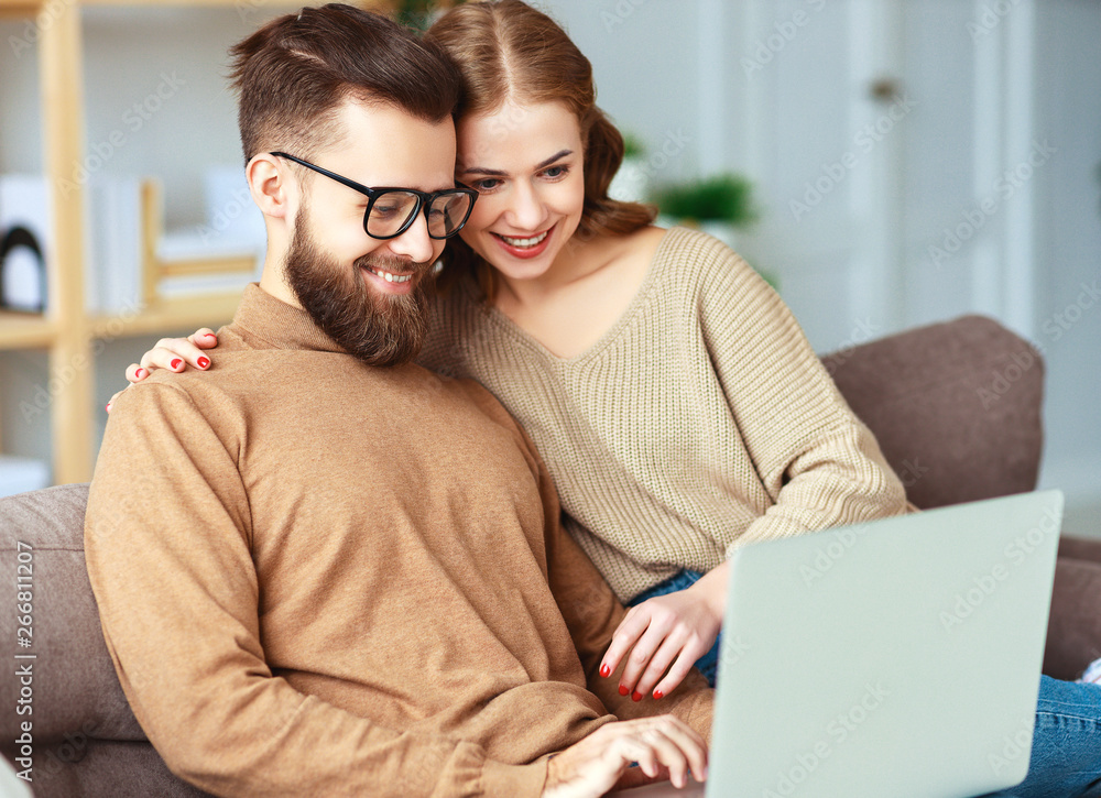 happy couple with laptop computer at home