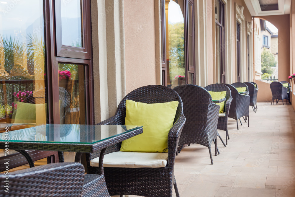 Outdoor coffee terrace with tables and wicker chairs